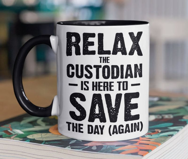 White coffee mug reading Relax, the custodian is here to save the day (again)