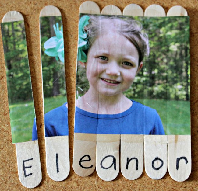Child's picture glued to a series of wood craft sticks and cut apart, with the letters of her name underneath