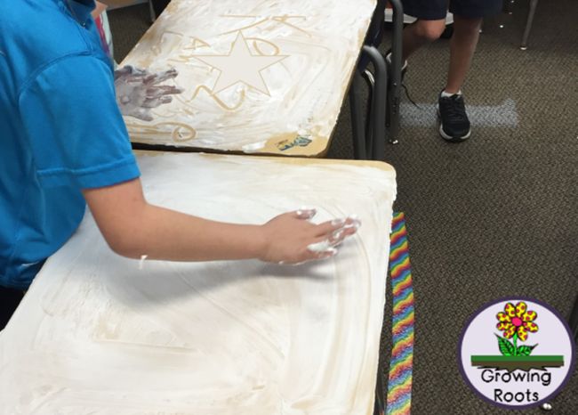 Students using shaving cream to clean their desks 