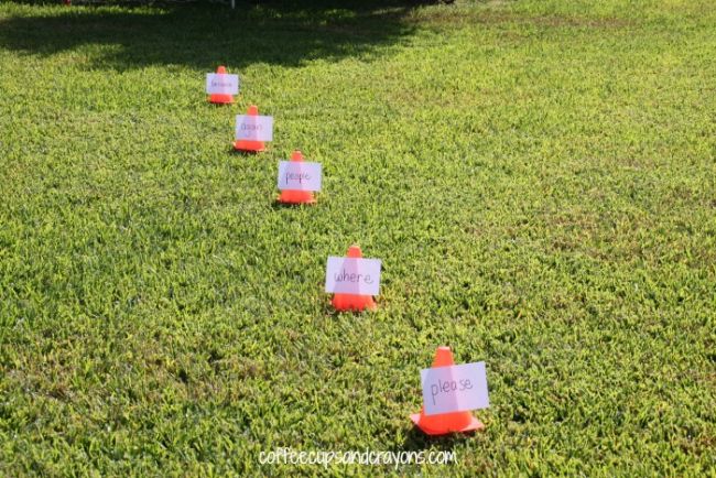 Series of small orange cones with words taped to them laid out on grass as an example of dollar store hacks for the classroom 