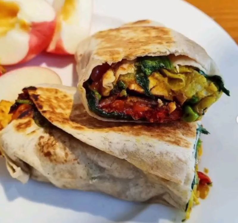 Wrap filled with samosa ingredients, cut in half and served on a plate