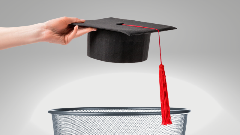 Photo of a mortarboard being dropped into a trash can