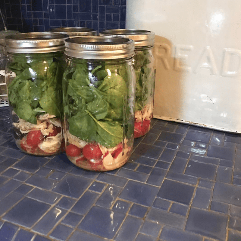 Salads in jars on a countertop, packed ahead for a week of teacher lunches