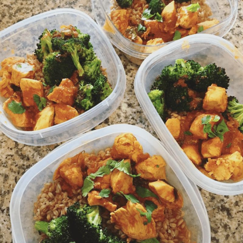 Individual plastic containers of chicken tikka masala with broccoli
